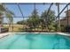 Screened-in pool overlooking a well-maintained backyard and view of the nearby golf course at 10645 Garda Dr, Trinity, FL 34655