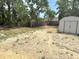 Spacious backyard featuring a storage shed and surrounded by mature trees and a wooden fence providing privacy at 11080 Jackdaw Rd, Weeki Wachee, FL 34614