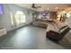Spacious living room with dark grey floors, large window, and sectional sofa at 11080 Jackdaw Rd, Weeki Wachee, FL 34614