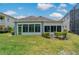 Expansive backyard featuring a sunroom, lush greenery, and well-maintained landscaping at 11401 Quiet Forest Dr, Tampa, FL 33635