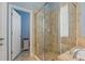 Clean bathroom featuring a glass-enclosed shower with beige tile surround, adjacent to a soaking tub at 11401 Quiet Forest Dr, Tampa, FL 33635
