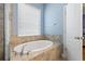 Relaxing bathroom featuring a luxurious soaking tub with tile surround and a large window at 11401 Quiet Forest Dr, Tampa, FL 33635