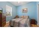 Cozy bedroom featuring hardwood flooring, a bright window and a comfortable bed with floral linens at 11401 Quiet Forest Dr, Tampa, FL 33635