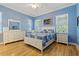 Charming bedroom with blue walls, hardwood flooring, and a comfortable queen-sized bed with matching decor at 11401 Quiet Forest Dr, Tampa, FL 33635