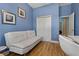Charming bedroom featuring light blue walls and sleek white futon with matching office chair at 11401 Quiet Forest Dr, Tampa, FL 33635