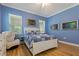 Comfortable bedroom featuring blue walls, hardwood flooring, and a queen-sized bed with matching decor at 11401 Quiet Forest Dr, Tampa, FL 33635