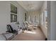 Bright sunroom featuring exercise equipment and a comfortable seating area with wicker chairs at 11401 Quiet Forest Dr, Tampa, FL 33635