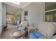 Inviting sunroom featuring wicker furniture and ample natural light streaming through large windows at 11401 Quiet Forest Dr, Tampa, FL 33635