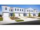 Charming light blue townhomes with well-manicured lawns on a clear, sunny day create an inviting curb appeal at 11410 Spectacled Dr, New Port Richey, FL 34654
