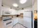 Clean kitchen features white appliances, tile backsplash, and plenty of cabinet space at 11631 Bayonet Ln, New Port Richey, FL 34654