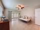 Bright bedroom features neutral-colored walls, a ceiling fan, and sliding doors to the lanai at 11821 Boynton Ln, New Port Richey, FL 34654