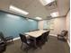 Conference room with a large meeting table, executive chairs, and contemporary artwork on the walls at 11821 Boynton Ln, New Port Richey, FL 34654