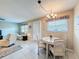 Bright dining area adjacent to a living room with neutral walls, tile flooring, and natural light at 11821 Boynton Ln, New Port Richey, FL 34654