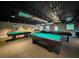 Spacious game room featuring multiple pool tables with dark ceilings and carpet flooring at 11821 Boynton Ln, New Port Richey, FL 34654