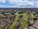 Scenic aerial view of a lush golf course interspersed with ponds, trees, and surrounded by houses offering a serene landscape at 11821 Boynton Ln, New Port Richey, FL 34654