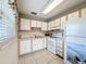 Traditional kitchen with white cabinetry, neutral countertops, and modern appliances at 11821 Boynton Ln, New Port Richey, FL 34654