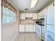 Clean kitchen featuring white appliances, cabinetry, laminate countertops and tile flooring at 11821 Boynton Ln, New Port Richey, FL 34654