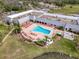 Aerial view of community pool and lounge area with palm trees and lake views at 11821 Boynton Ln, New Port Richey, FL 34654