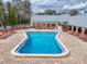 Beautiful community hourglass-shaped pool surrounded by chairs for lounging at 11821 Boynton Ln, New Port Richey, FL 34654
