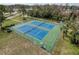Aerial view of two blue outdoor tennis courts surrounded by lush greenery, offering recreation and fitness opportunities at 11821 Boynton Ln, New Port Richey, FL 34654