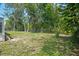 Well-maintained backyard featuring mature trees and a chain link fence at 12106 Bear Creek Ln, Hudson, FL 34667