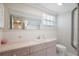 Bathroom featuring a pink vanity with oval sink, toilet, and shower/tub with shower curtain at 12106 Bear Creek Ln, Hudson, FL 34667