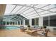 Enclosed pool room with lounge area, featuring tiled flooring and a vaulted ceiling at 12106 Bear Creek Ln, Hudson, FL 34667