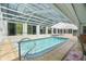 Bright and airy pool area featuring a tiled floor, glass roof, and sun-filled windows at 12106 Bear Creek Ln, Hudson, FL 34667