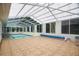 The enclosed pool area features a retractable roof, tiled floors, and is surrounded by windows at 12106 Bear Creek Ln, Hudson, FL 34667