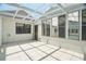 Bright sunroom with tiled floor, sliding doors and multiple windows at 12106 Bear Creek Ln, Hudson, FL 34667