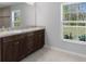 Bathroom featuring double sink vanity, granite countertop, and a large window overlooking a well-manicured lawn at 12192 Eskimo Curlew Rd, Weeki Wachee, FL 34614