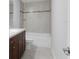Bathroom showcasing the tiled shower-tub and dark wood vanity at 12192 Eskimo Curlew Rd, Weeki Wachee, FL 34614