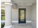 A detailed view of the front door with decorative glass inserts, complemented by a neutral gray exterior at 12192 Eskimo Curlew Rd, Weeki Wachee, FL 34614