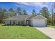 Charming single-story home boasts a well-manicured lawn, gray exterior, and attached two-car garage at 12192 Eskimo Curlew Rd, Weeki Wachee, FL 34614