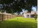 Backyard featuring a spacious green lawn, wooden fence, and a peek at the home's exterior at 1221 Etta Ave, Spring Hill, FL 34609
