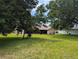 Lush green backyard view with mature trees and screened lanai offering a serene outdoor space at 1221 Etta Ave, Spring Hill, FL 34609