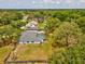 Aerial view of a home surrounded by lush trees and greenery, with a pool in the backyard at 1222 Huntington Ave, Spring Hill, FL 34609