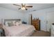 Comfortable bedroom featuring a cozy bed, a ceiling fan, and plenty of natural light at 12250 Lacey Dr, New Port Richey, FL 34654