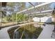 View of this screened-in backyard swimming pool with a view of two storage sheds at 12250 Lacey Dr, New Port Richey, FL 34654