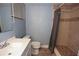A full bathroom featuring a single sink vanity, a toilet, a tiled shower with a shower curtain, and a window at 12411 Yorktown Ln, Hudson, FL 34667