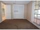 Neutral carpeted bedroom featuring a closet with sliding doors and a sunroom accessible through the window at 12411 Yorktown Ln, Hudson, FL 34667