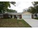 Charming single-story home features a two-car garage and well-maintained front yard at 12411 Yorktown Ln, Hudson, FL 34667