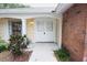 Welcoming front entrance with double doors, yellow trim and brick accents surrounded by lush landscaping at 12411 Yorktown Ln, Hudson, FL 34667