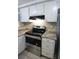Updated kitchen featuring granite countertops, white cabinetry, and stainless steel appliances at 12411 Yorktown Ln, Hudson, FL 34667