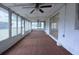 Bright sunroom featuring windows, ceiling fans, and red carpet at 12411 Yorktown Ln, Hudson, FL 34667