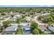 Expansive aerial view showcasing neighborhood homes, lush trees, and pool at 13003 Sandburst Ln, Hudson, FL 34667