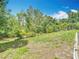 The beautiful backyard is green with mature trees and tropical landscaping at 13003 Sandburst Ln, Hudson, FL 34667