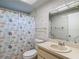 Bright bathroom with shower/tub combo, tiled walls, and vanity with countertop and mirror at 13003 Sandburst Ln, Hudson, FL 34667