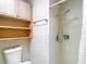 Bathroom featuring a toilet with wall storage, a shower with adjustable head, and a towel rack at 13003 Sandburst Ln, Hudson, FL 34667