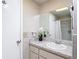 Bathroom featuring white tiled walls, vanity with marble countertop, mirror, and a decorative flower arrangement at 13003 Sandburst Ln, Hudson, FL 34667